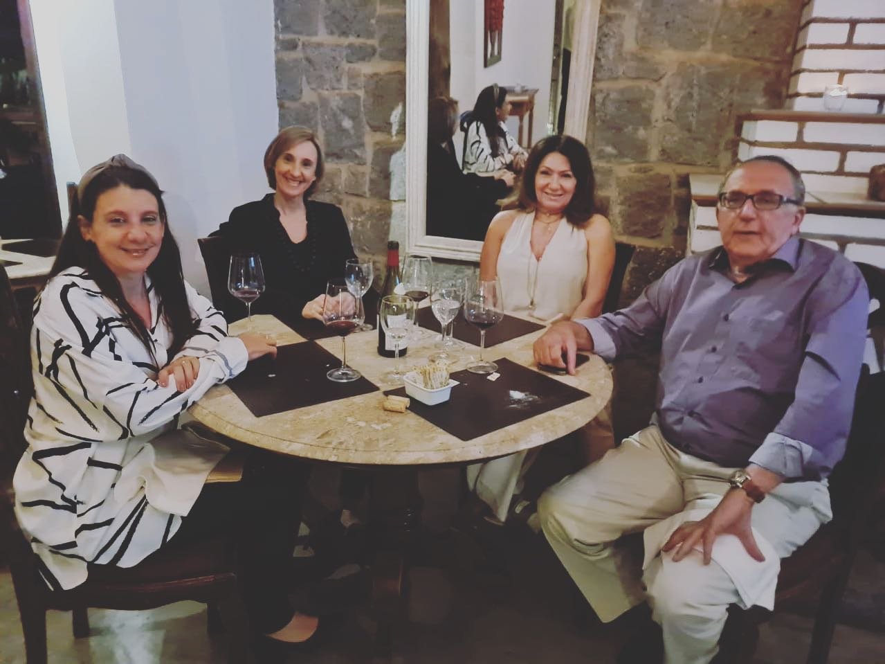 Quatro clientes celebrando à mesa no Jardim Secreto
